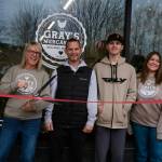 Grays Mercantile founder Summer Stumpf prepares to cut the ribbon, surrounded by family, Nov. 15, 2025. Grace Gorenflo/Valley Record