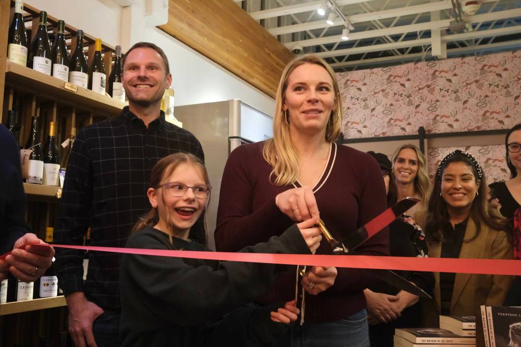Books and Bottles owner Julie Thomas prepares to the cut the ribbon on her shop, joined by her husband and daughter, Nov. 14, 2025. Grace Gorenflo/Valley Record