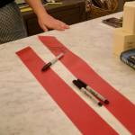 Guests sign the ribbon at the ribbon-cutting event of Books and Bottles, Nov. 14, 2025. (Grace Gorenflo/Valley Record)