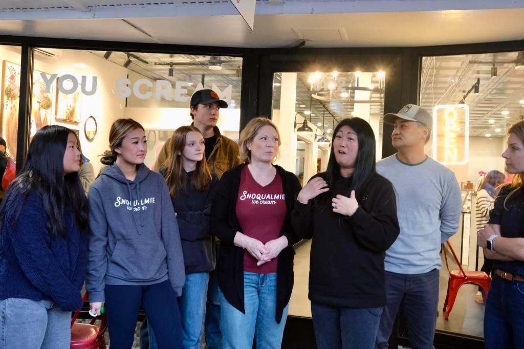 Snoqualmie Ice Cream co-owners Heather Dean (left middle) and Julie Chung (right middle) talk to the crowd before their grand re-opening ribbon cutting, Nov. 19, 2025.