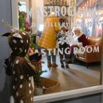 Costumed as a reindeer, Fritz Rode peers through a window at Mastrogiannis Distillery where kids and families queued up to meet Santa in North Bend on Saturday, Dec. 6.