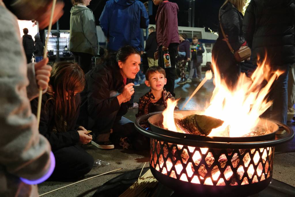 Destiny Lasnik helps her son Atlas, 6, roast a marshmallow at the Holly Days festival in North Bend on Saturday, Dec. 6. A two-block stretch of North Bend Way was closed to cars to make room for firepits, vendor tents and a performance stage. Photos by Aaron Gustafson