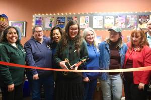 Ellen Rowan, a North Bend Art & Industry co-founder and the Center for Creativitys first staff member, prepares to the cut the ribbon, Dec. 8, 2025. (Grace Gorenflo/Valley Record)