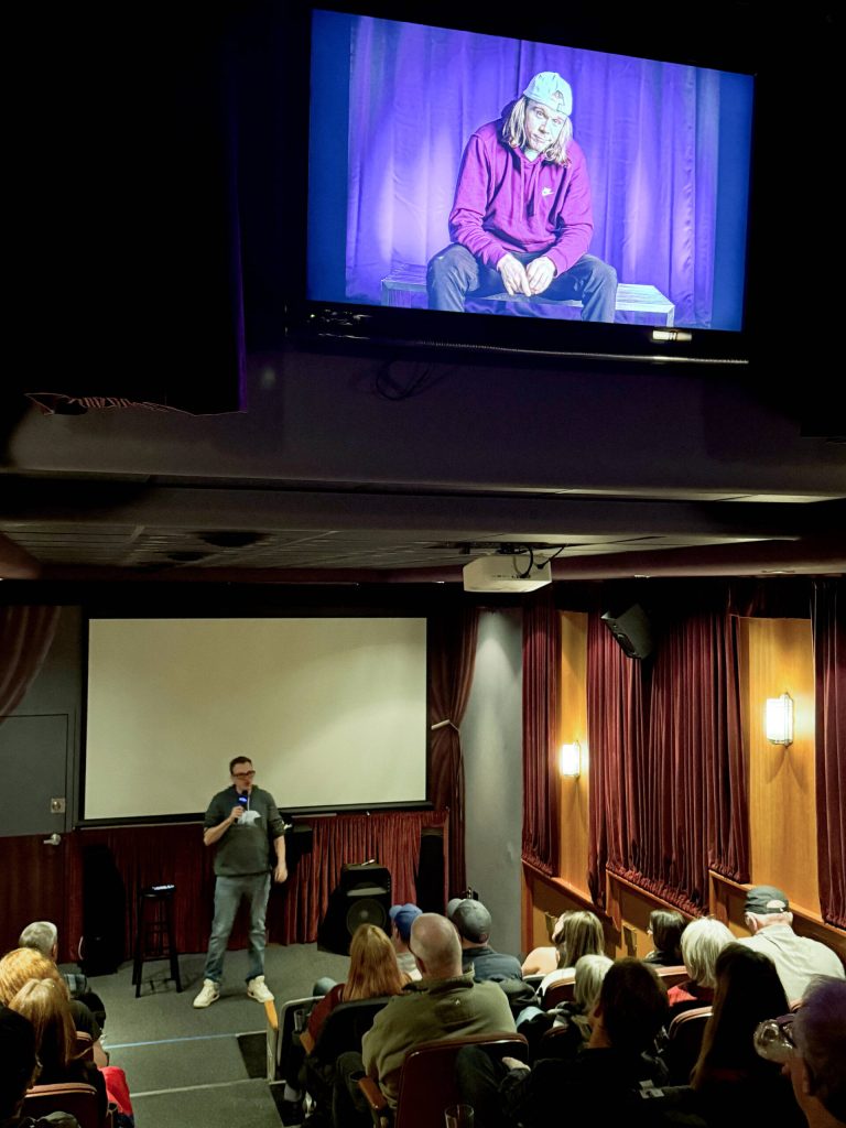 Andrew Rivers pictured on a TV monitor as well as seen live on stage at The Tin Room Theater in Burien. Photo by James Gibowski