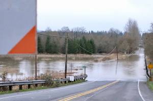 Flood waters flow over NE 124th Street at West Snoqualmie Valley Road NE outside Duvall, Dec. 9, 2025. (Grace Gorenflo/Valley Record)