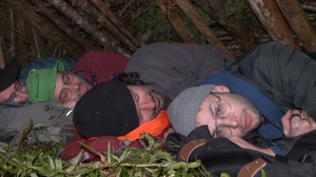 The Try Guys get ready for sleep in the bushcraft shelter they made during their night in the wilderness.