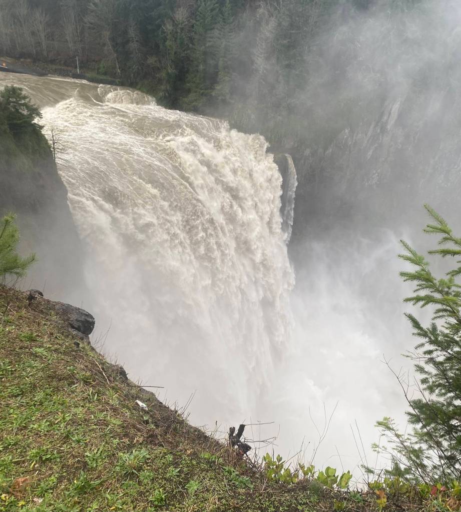 The Snoqualmie River shoots over Snoqualmie Falls the morning of Dec. 9, 2025. As flooding hit the Snoqualmie Valley, the falls essentially created their own weather system, with water pouring down on those who stood near. (William Shaw/Valley Record)