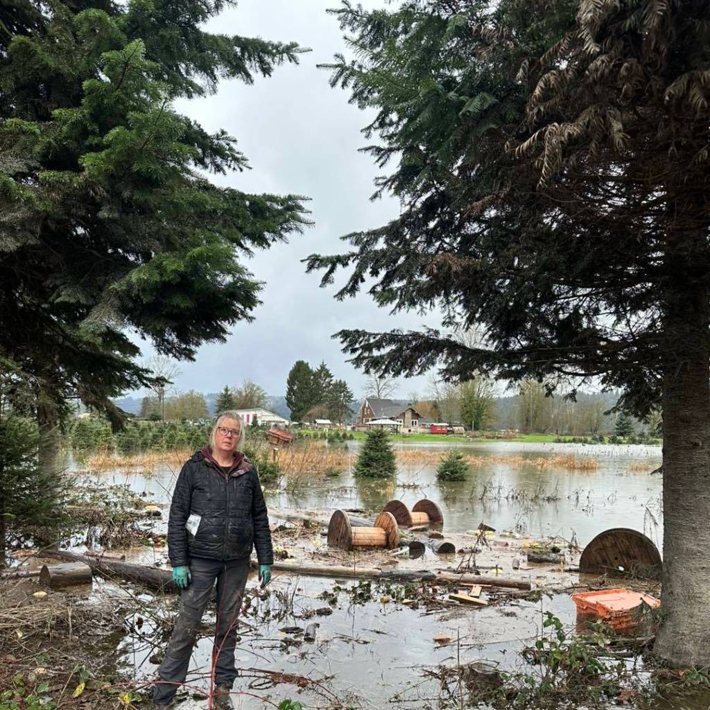Lora Lee, owner of Lora Lees Family Farm, stands near flood damage, December 2025. Photo courtesy of Lora Lees