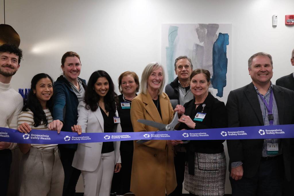 Snoqualmie Valley Health CEO Renee Jensen (right) and North Bend Mayor Mary Miller cut the ribbon on the new clinic, Nov. 19, 2025. They are surrounded by SVH providers and leaders.