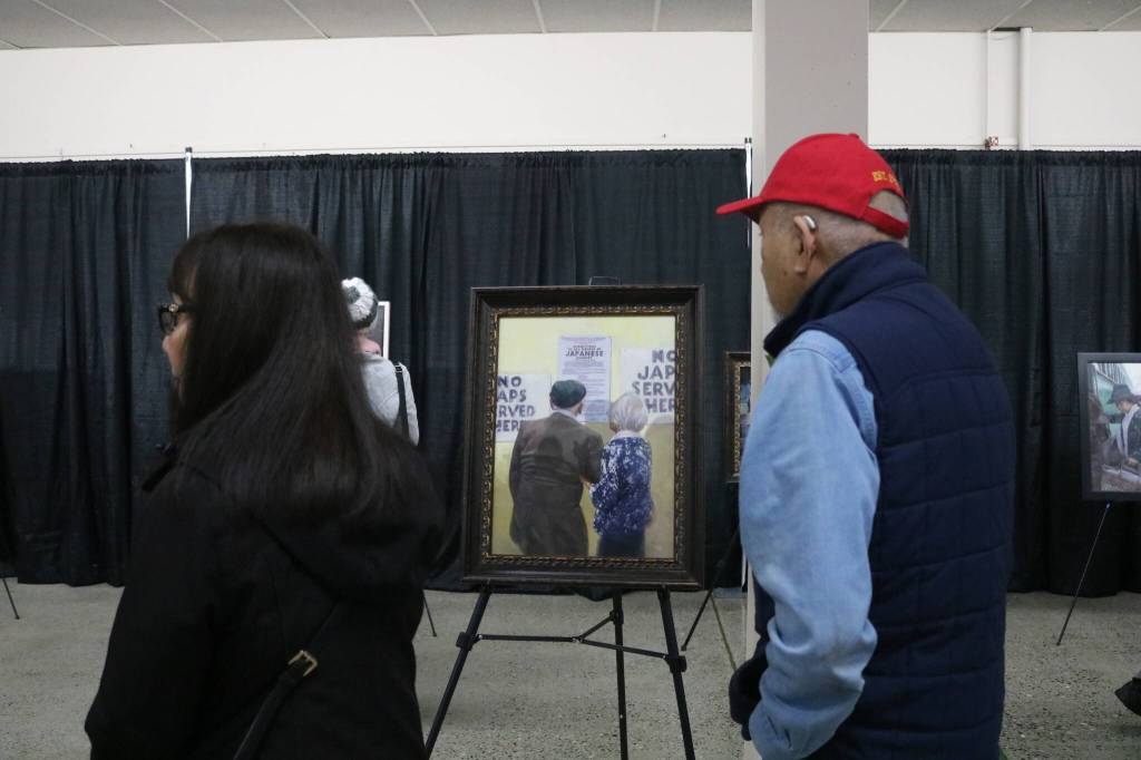 Attendees take in art by Chris Hopkins exploring the incarceration experience. Photo by Bailey Jo Josie/Sound Publishing