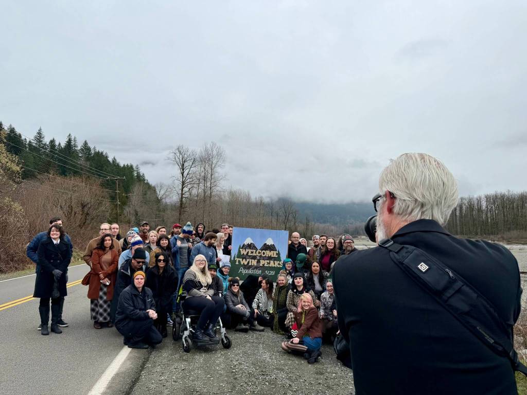 Stephen Miller, author of Twin Peaks Blog, takes photos of fans with the Welcome to Twin Peaks sign on Twin Peaks Day 2026. (Grace Gorenflo/Valley Record)