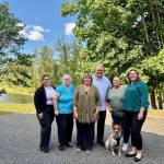 The staff of Hauglie Insurance, along with Copper the office dog, stands for a photo outside the agency by the Snoqualmie River, July 3, 2025. From left: Sophia Amaya Cruz, Elizabeth Gildersleeve, Laurie Hauglie, Kevin Hauglie, Samantha Darnell, Angela Donaldson. (Grace Gorenflo/Valley Record)
