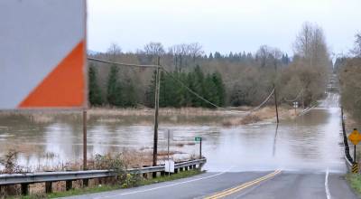 Flood waters flow over NE 124th Street at West Snoqualmie Valley Road NE outside Duvall, Dec. 9, 2025. (Grace Gorenflo/Valley Record)