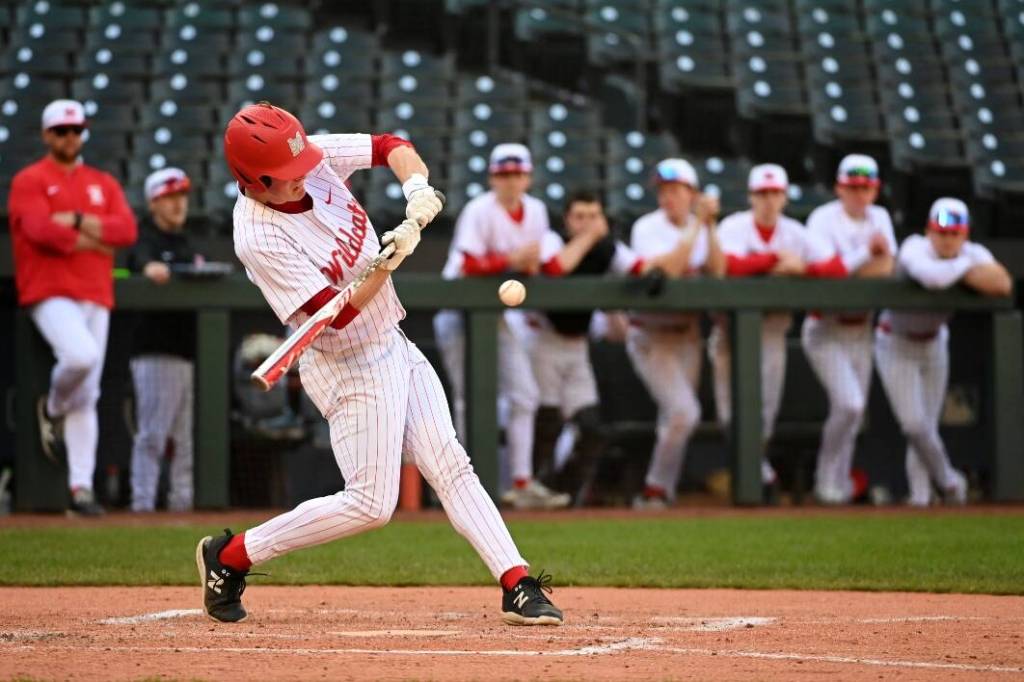Mount Sis Austin Meyers takes a swing with his teammates watching from the dugout.