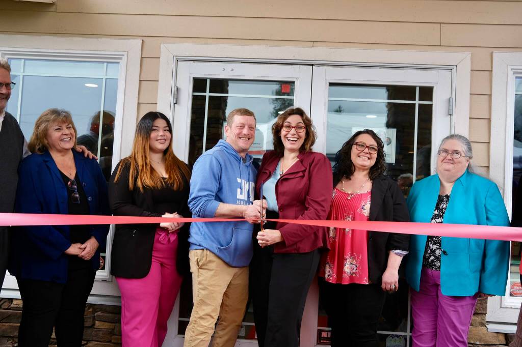 Angela Donaldson (center right), surrounded by peers and family, prepares to cut the ribbon at the grand opening of her insurance agency, March 24, 2026.