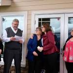 Angela Donaldson (center right) hugs her mom, Laurie Hauglie, as her dad, Kevin Hauglie, reads a speech, March 24, 2026. The Hauglies have sold their insurance business to Donaldson after 40 years.