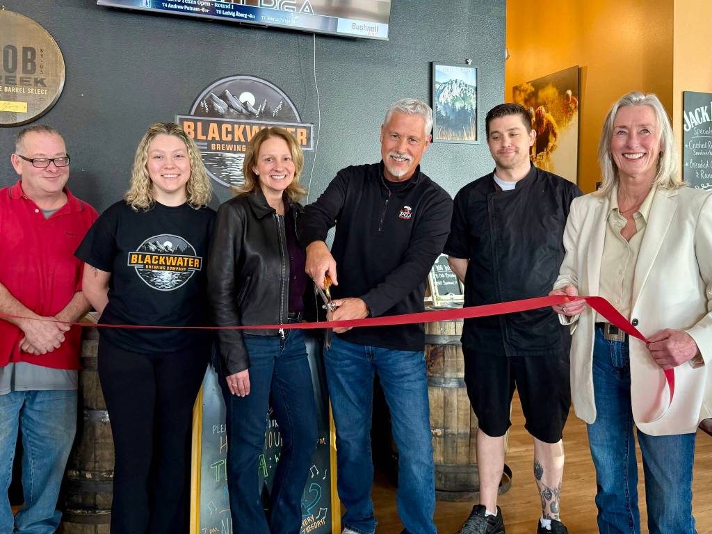 Owner Greg Steed (center) prepares to cut the ribbon at Blackwater Brewing, April 2, 2026.