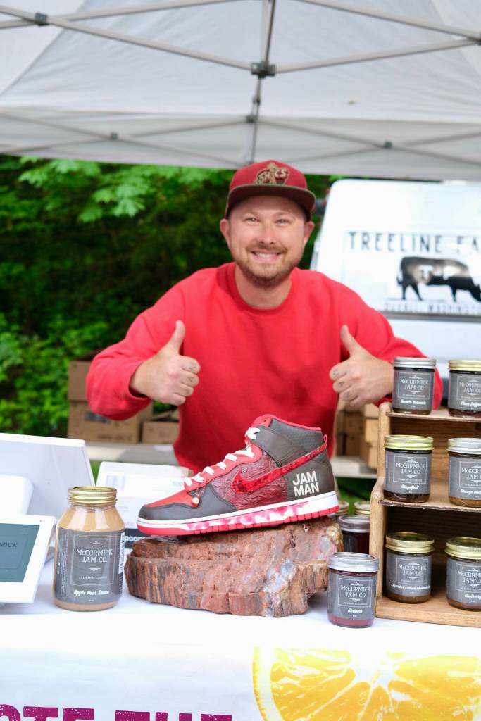 Grace Gorenflo / Valley Record
Dane McCormick, co-owner of McCormick Jam Co., stands for a photo with a shoe that reads Jam Man at the Duvall Farmers Market, May 7, 2026.
