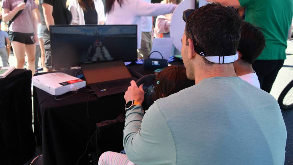 Summer Celebration attendees engage in a hydroplane racing simulator. Andy Nystrom/ staff photo