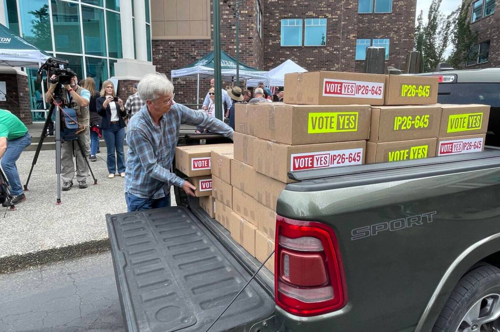 A volunteer for Lets Go Washington unloads boxes of petitions for Initiative 645 that were turned in to the Secretary of States office on July 2. The measure to repeal Washingtons new income tax was certified for the November ballot on July 15. (Photo by Jerry Cornfield / Washington State Standard)