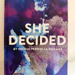 The cover of She Decided by Nicole Perriella-Rehmke uses watercolor art made by Perriella-Rehmkes daughter. (Grace Gorenflo/Valley Record)